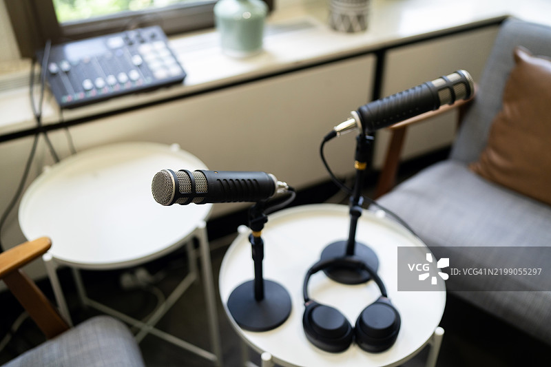 专业播客录音设备，配有麦克风和耳机，置于录音室环境中图片素材