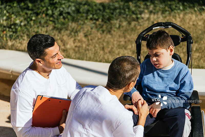 医疗团队照顾坐在轮椅上的脑瘫儿童图片素材