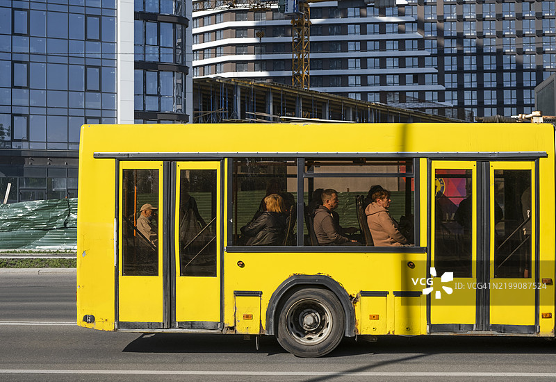 鲜艳的黄色公交车在阳光明媚的日子里穿梭于基辅繁忙的街道上图片素材