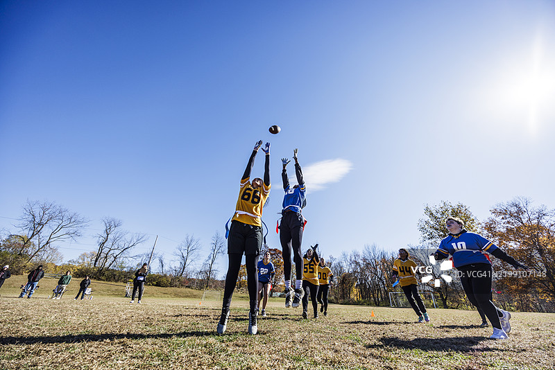 女性球员在空中跳起接球，正在进行旗帜足球比赛图片素材