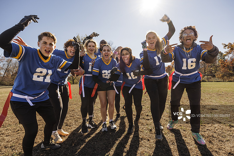兴奋的女子橄榄球队在运动场上庆祝胜利图片素材