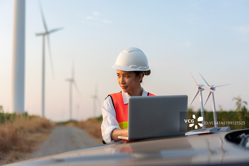 女性工程师在风电场使用笔记本电脑工作图片素材