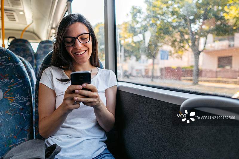 年轻女性在公交车上使用手机图片素材