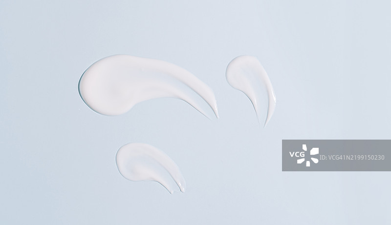 蓝色背景上的化妆品奶油涂抹痕迹图片素材