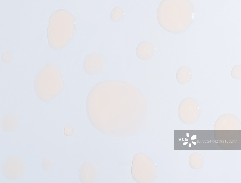 蓝色背景上的美容精华液滴图片素材