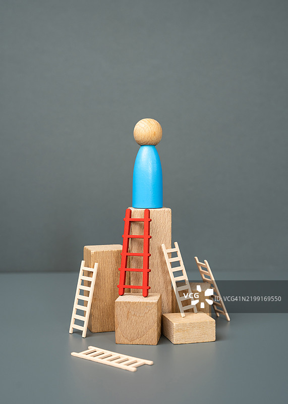 这个男人在红色梯子的帮助下达到了顶峰，选择正确的方式和工具以实现成功的理念，经历困难，达到精通的巅峰。图片素材