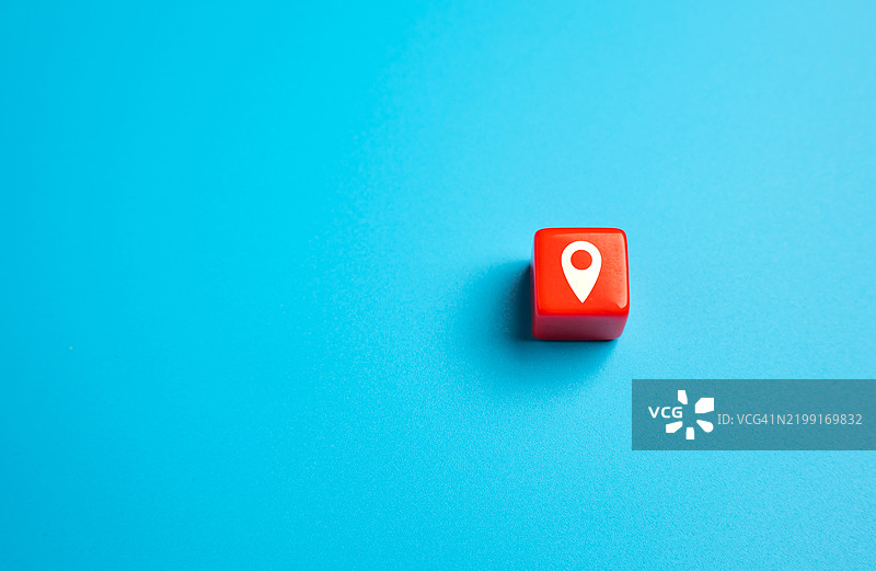 蓝色背景上的红色方块，带有地理定位符号，寻找新的旅行地点，关于有趣目的地的指南，广告和宣传。图片素材