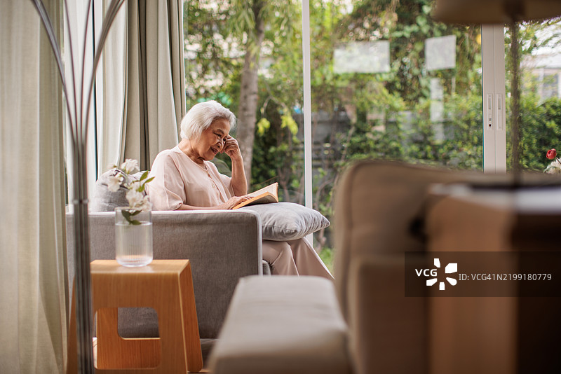年长的泰国女性在阅读一本书图片素材