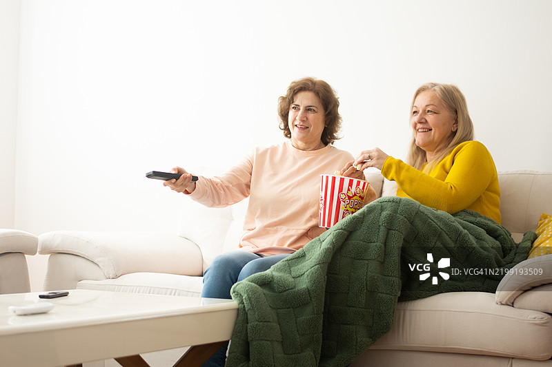 老年女性在家看电视并欢笑图片素材