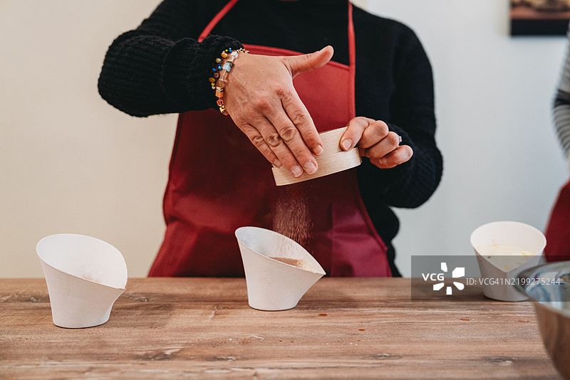 糕点厨师在厨房里将面粉筛入碗中图片素材