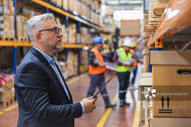 仓库中使用数字平板的工厂经理图片素材