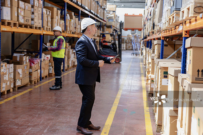 仓库中使用数字平板的工厂经理图片素材