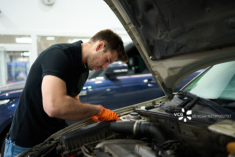 机械师在汽车修理店检查汽车发动机图片素材