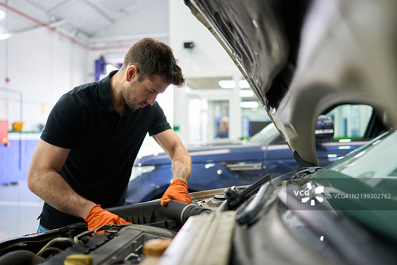 机械师在汽车修理店检查汽车发动机图片素材