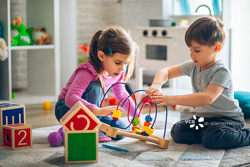 孩子们在儿童房里玩教育玩具图片素材