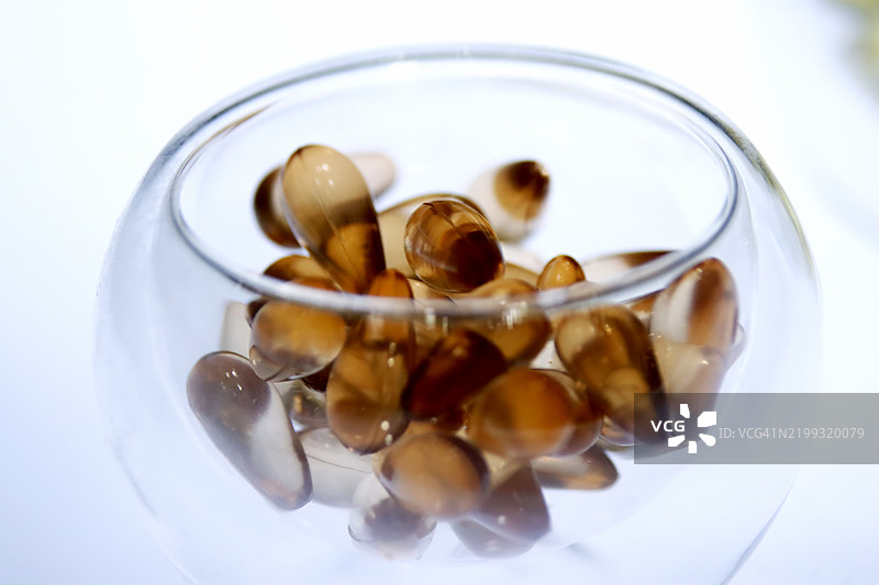 玻璃碗中的闪亮鱼油胶囊图片素材