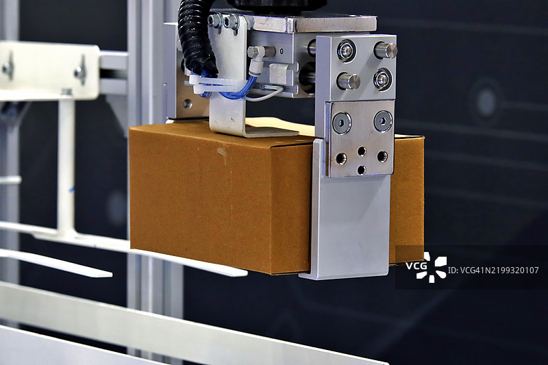 机器人手臂将纸箱转移到输送带上图片素材
