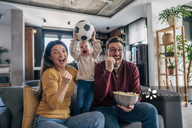 家庭在家庆祝足球胜利图片素材