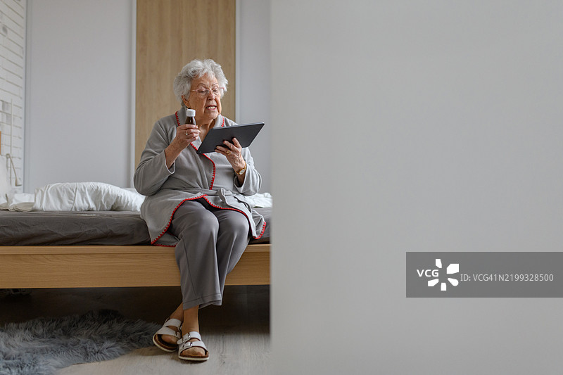 老年女性正在阅读药物说明书和剂量指示。为老年人管理药物。图片素材