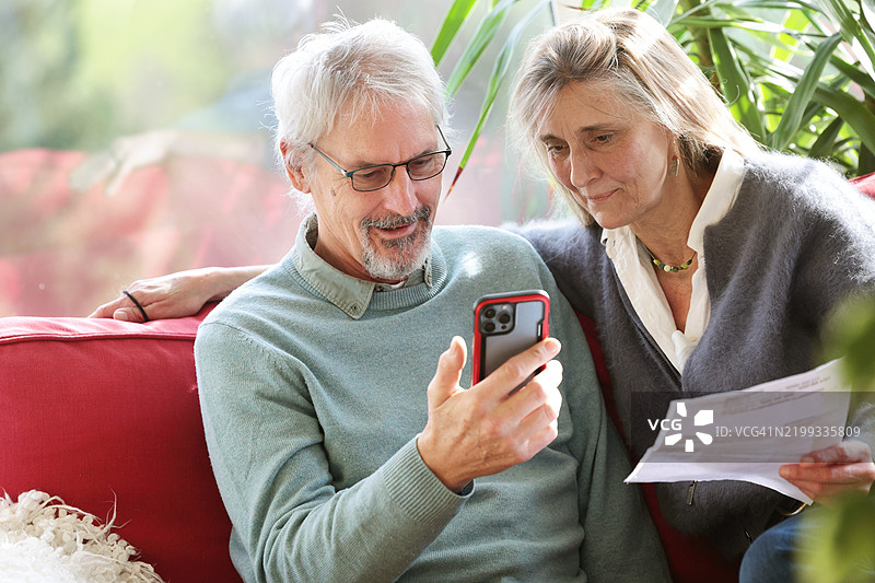 夫妻在家中使用手机查看财务情况图片素材