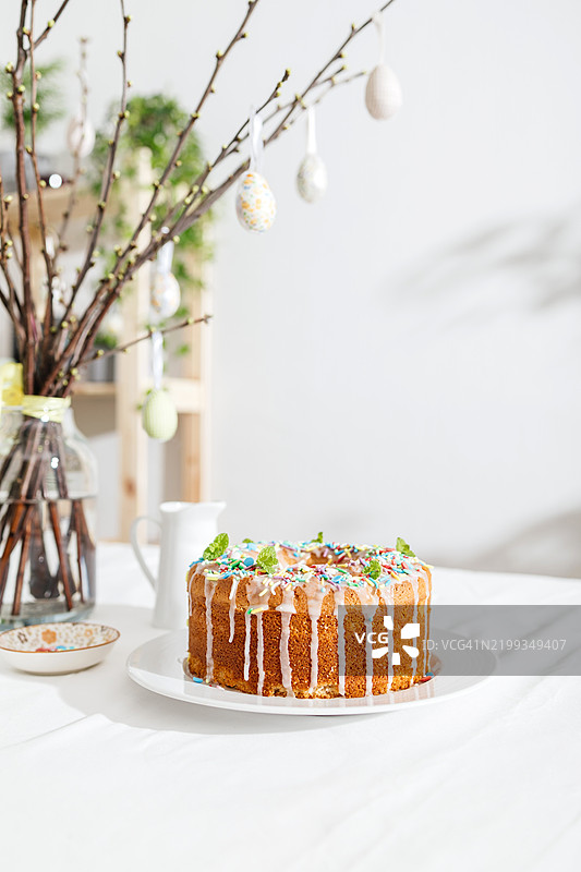 阳光明媚的日子里，桌子上摆放着装饰有糖霜和糖粒的复活节蛋糕。复活节烘焙。图片素材