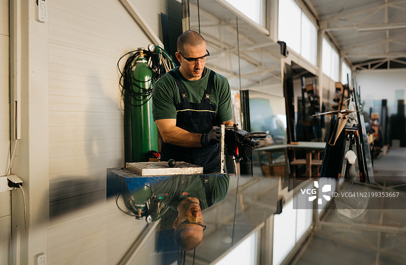 年轻帅气的玻璃切割工图片素材