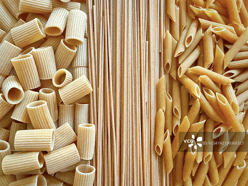 从上方俯视的各种生全麦意大利面、通心粉和中等粗纹意大利面的特写镜头图片素材