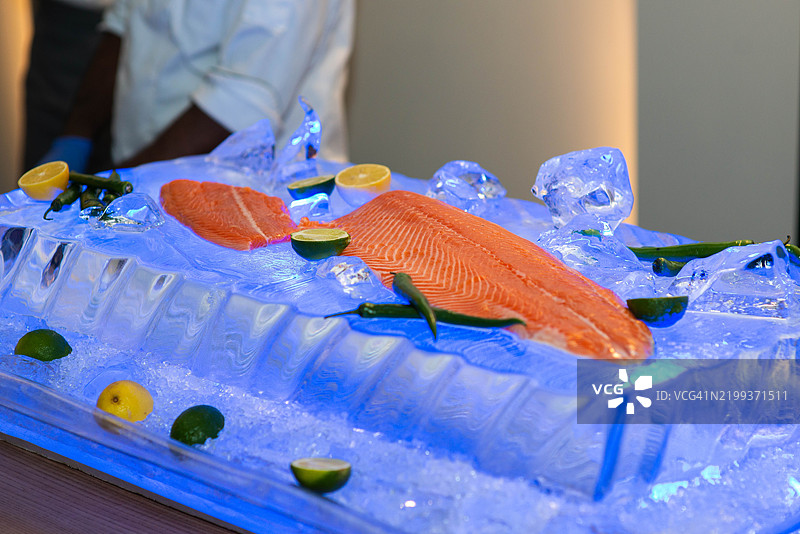 新鲜的太平洋鲑鱼配柠檬，放在冰上图片素材
