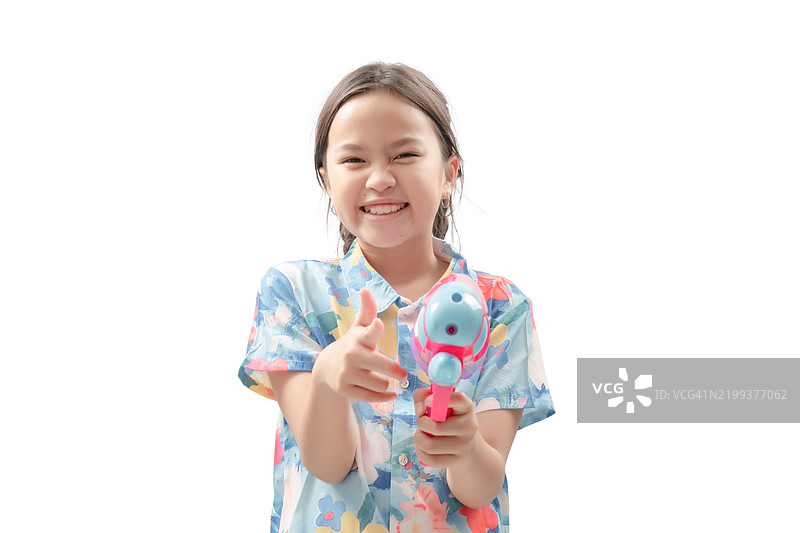 一个小女孩拿着玩具枪对着镜头指着。图片素材