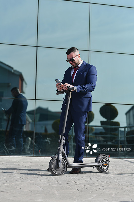 愉快的男性高兴地结束工作日，阅读朋友发来的安排夜晚外出的信息图片素材