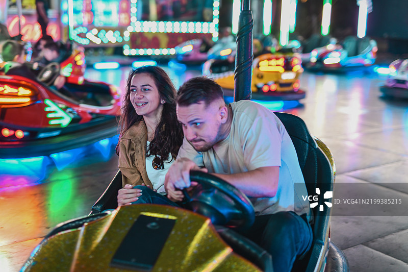 男朋友在最后一刻紧张而专注地躲避碰碰车的碰撞图片素材