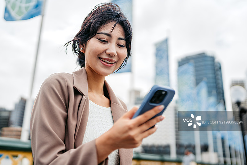 年轻的亚洲女商人在澳大利亚悉尼达令港使用手机图片素材