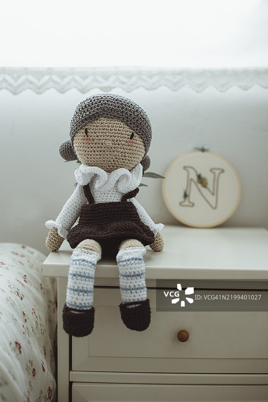 卧室床头柜上的钩针娃娃（毛绒玩具）特写图片素材