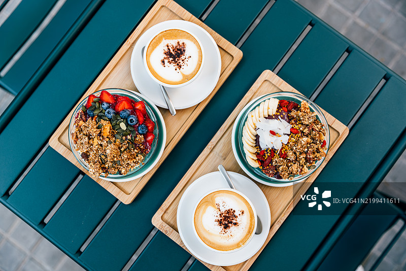 健康有机早餐，包括阿萨伊碗和咖啡，在咖啡馆内高角度拍摄。图片素材