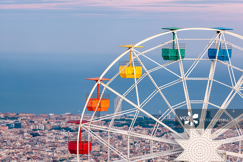 西班牙巴塞罗那城市景观上的多彩摩天轮与提比达博山图片素材