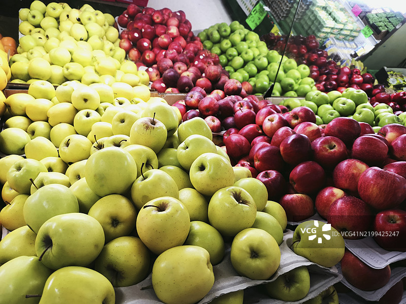 新鲜苹果堆成两种颜色，摆放在水果和蔬菜市场上图片素材