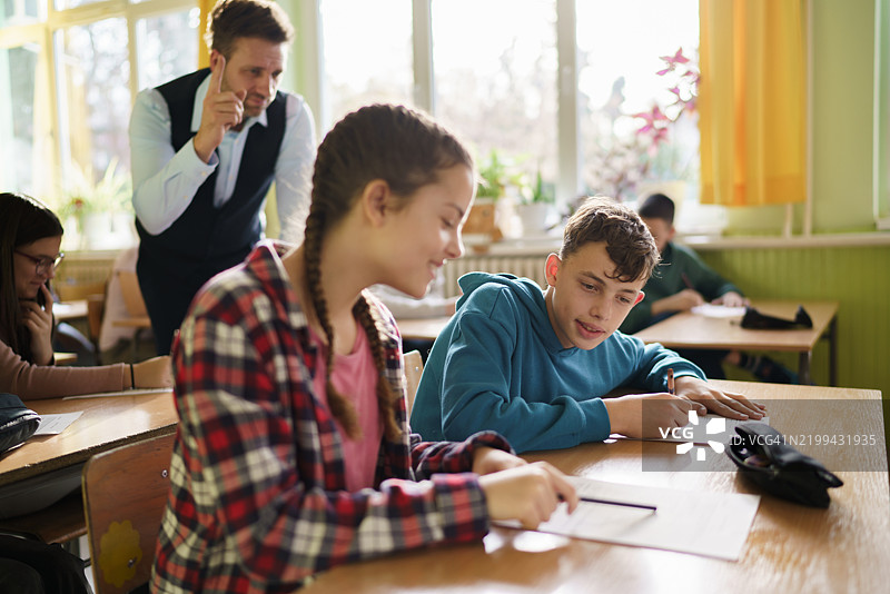 一位老师警告正在考试中抄袭的学生图片素材