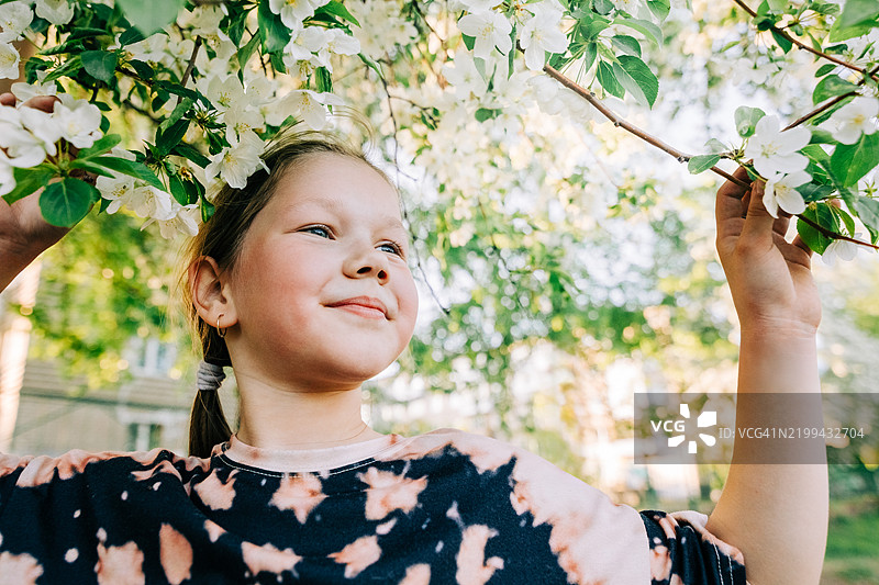 快乐的孩子在户外享受春天盛开的自然景色图片素材