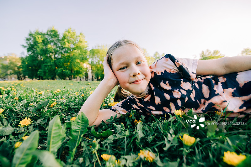 微笑的孩子在阳光明媚的草地上放松图片素材