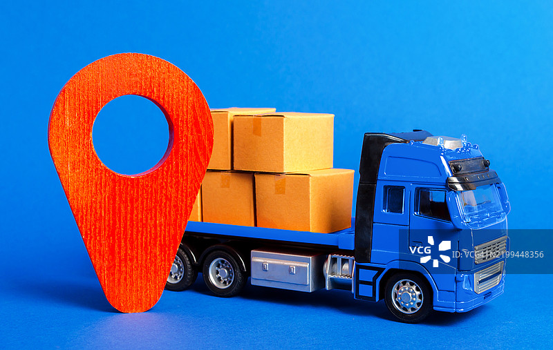 一辆装满箱子的蓝色卡车和一个红色指示器，提供货物运输、产品、物流和基础设施的运输服务，承运人位置，包裹追踪。图片素材