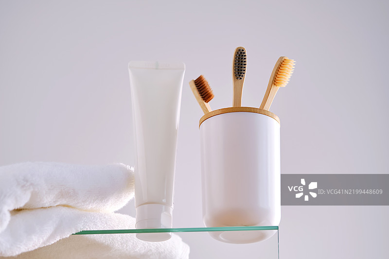 浴室玻璃架上的牙刷、牙膏和洗浴用品图片素材