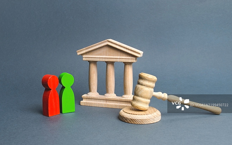 两位对立的当事人在法院附近站立，法官的槌子象征着冲突解决，原告与被告的法庭案件，解决争端，司法系统。图片素材