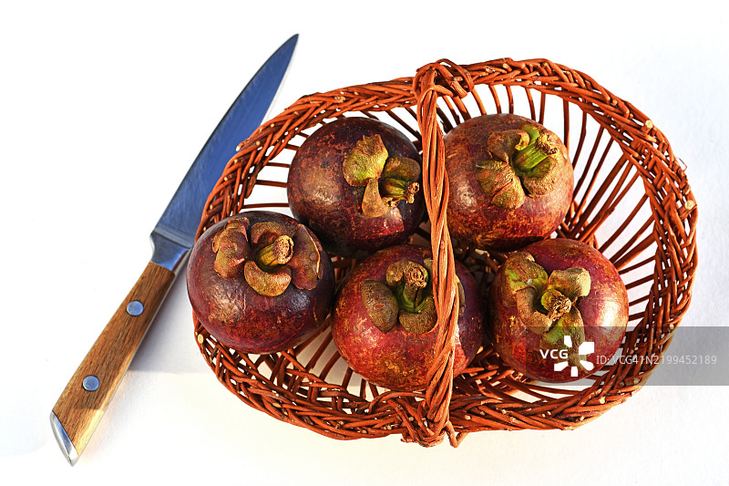 高角度视图的山竹放在白色背景的篮子里图片素材