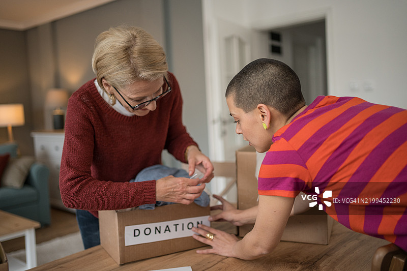 女性在家中整理衣物捐赠图片素材