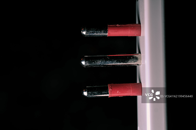 黑色背景下的三插头电源插头图片素材