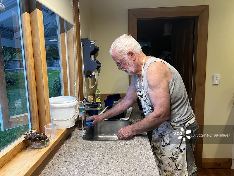 伤心的活跃老人在厨房水槽里洗碗图片素材