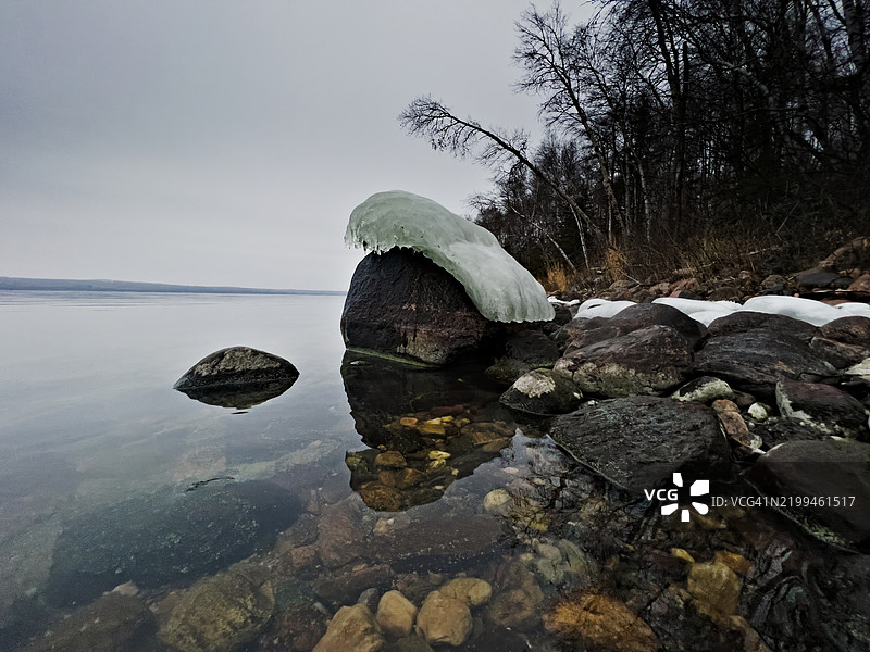 湖岸岩石上冬季冰雪的最后残余图片素材