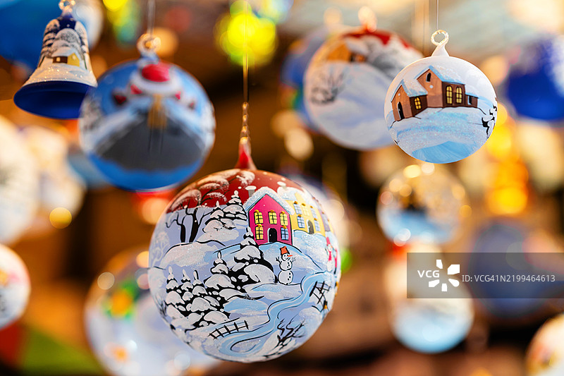 圣诞市场摊位上悬挂的圣诞树装饰球，节日气氛浓厚图片素材