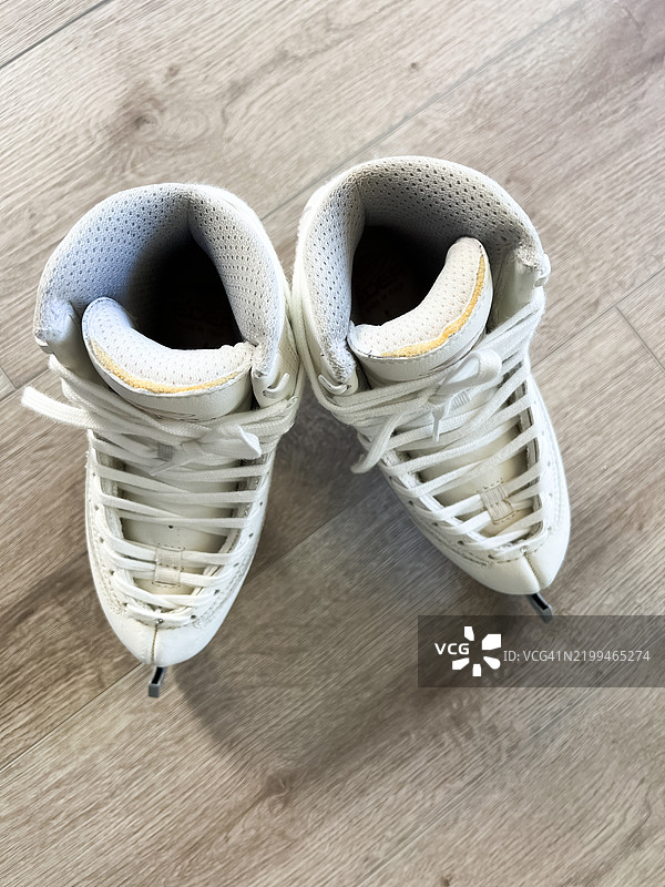 白色冰鞋在木地板上滑行图片素材