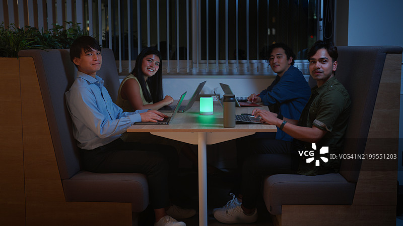 多种族团队在夜间会议中与智能音箱放松的肖像图片素材